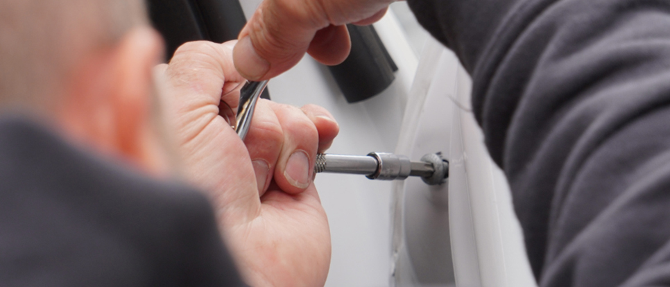 Repair Management Close up of technician using a screwdriver on van door